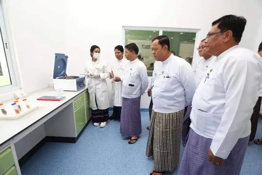 Officials being shown the centrifuge on the completed laboratory bench
