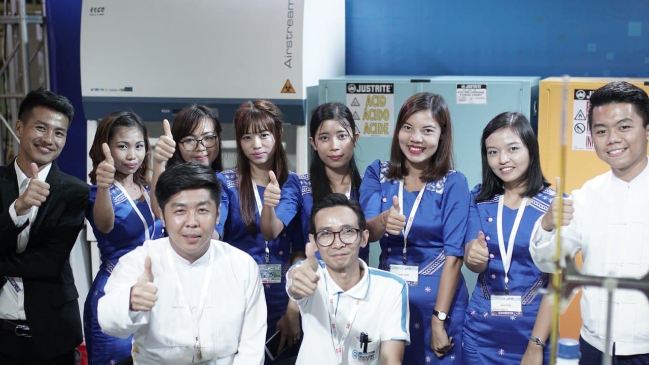 FIRST PRIME team giving a thumbs-up in front of the Esco biosafety cabinet and Justrite safety cabinets
