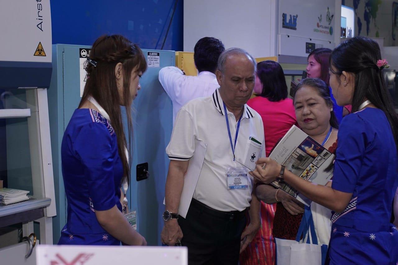 A FIRST PRIME host handing the company profile booklet to a visitor