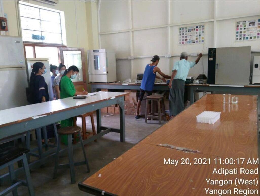 The Molecular Lab before renovation — students and staff around worn timber benches with old incubators against the wall